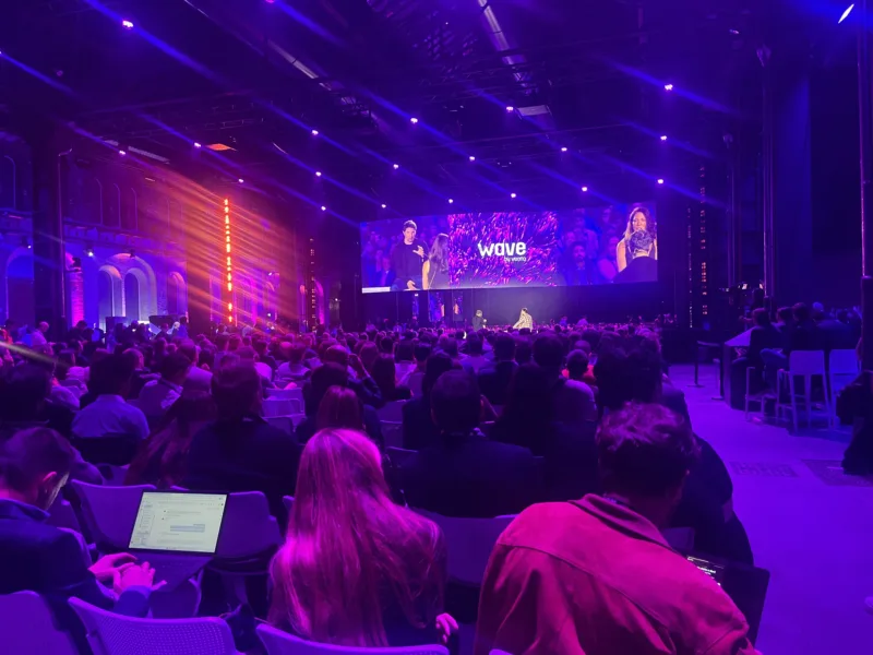 Publiek in de paars verlichte hoofdzaal van de OGR in Turijn tijdens een sessie op het hoofdpodium van Wave by Vento.
